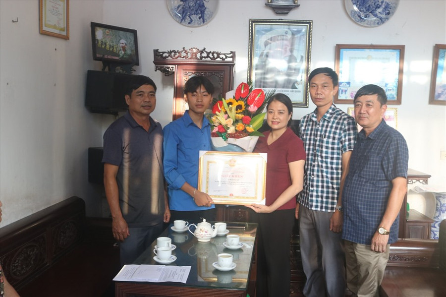 Bà Lưu Thị Nghiêm-Phó Chủ tịch UBND huyện Hải Hậu (tỉnh Nam Định) biểu dương hành động dũng cảm cứu người của em Bùi Hải An. Ảnh: Trần Loan/TTO