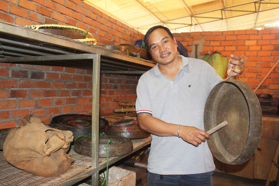 Anh Hyơm (làng Tiêng 2, xã Tân Sơn, TP. Pleiku) giữ gìn các bộ cồng chiêng của gia đình rất cẩn thận. Ảnh: Phan Lài