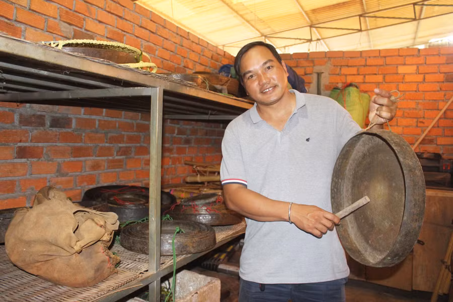 Anh Hyơm (làng Tiêng 2, xã Tân Sơn, TP. Pleiku) giữ gìn các bộ cồng chiêng của gia đình rất cẩn thận. Ảnh: Phan Lài