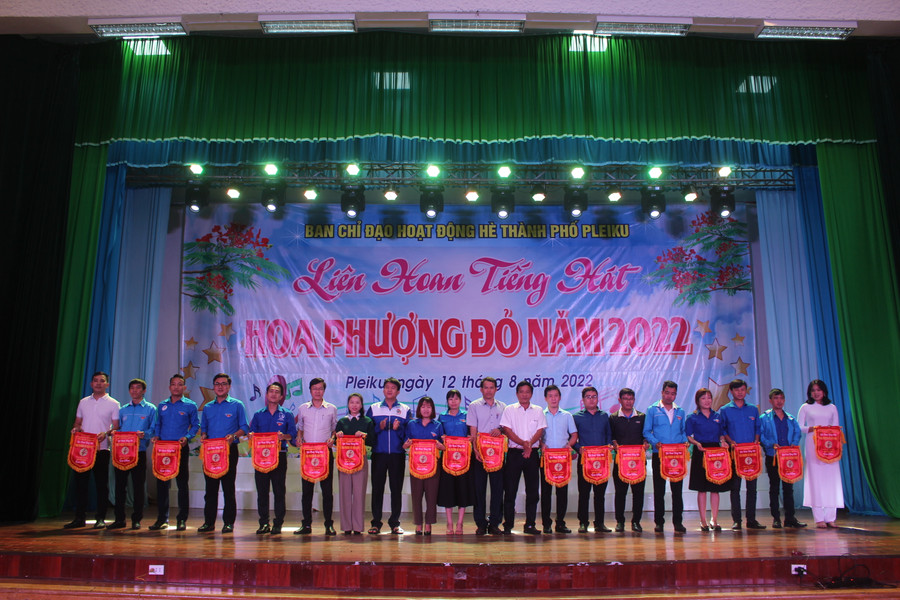 Ban tổ chức trao cờ lưu niệm cho các đội thi tham gia liên hoan tiếng hát Hoa phượng đỏ. Ảnh: Minh Nhật