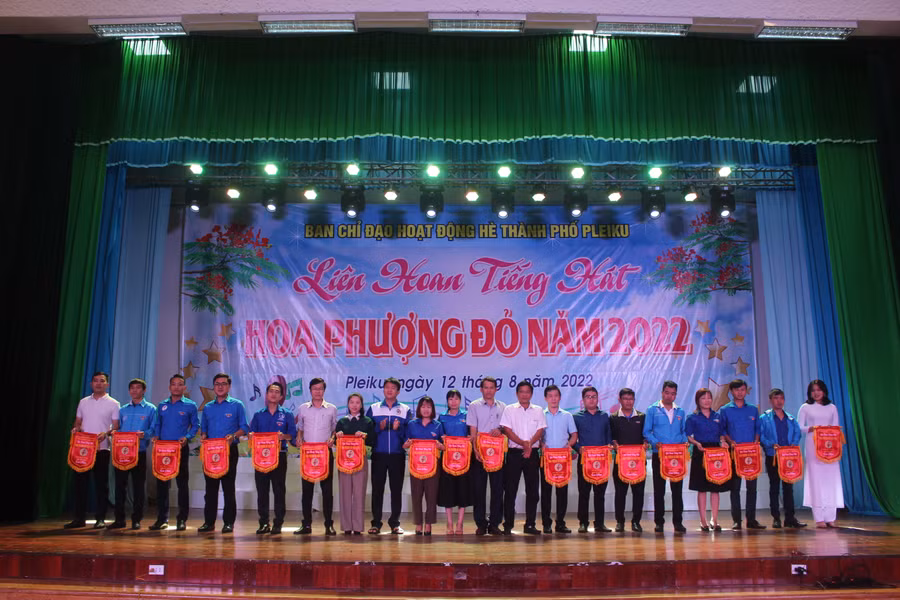 Ban tổ chức trao cờ lưu niệm cho các đội thi tham gia liên hoan tiếng hát Hoa phượng đỏ. Ảnh: Minh Nhật