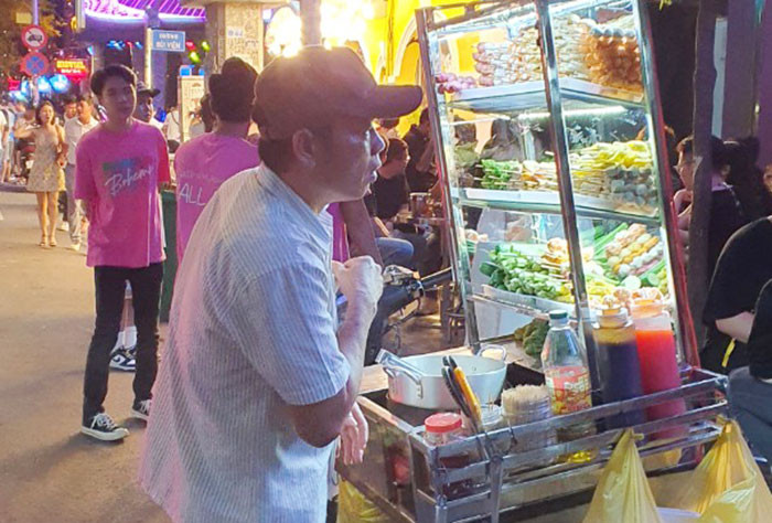 Ở một góc vỉa hè là cuộc mưu sinh thâu đêm của người bán hàng rong.