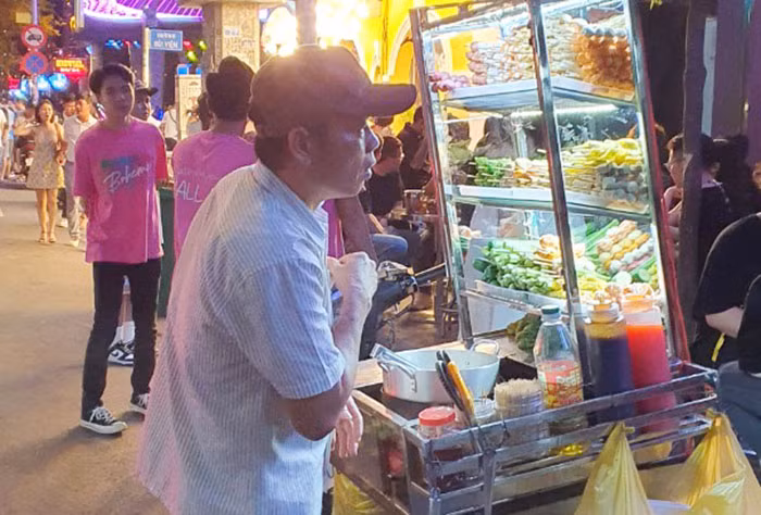 Ở một góc vỉa hè là cuộc mưu sinh thâu đêm của người bán hàng rong.