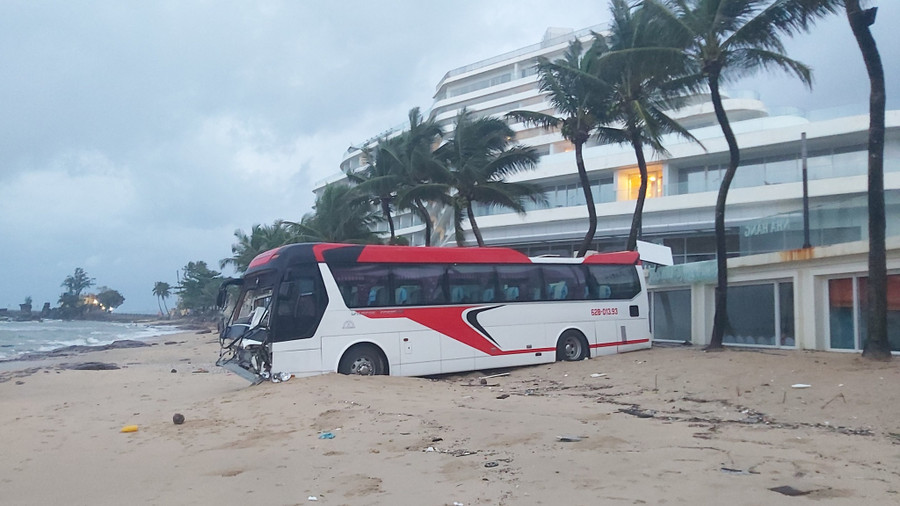 Chiếc xe khách lao xuống bãi biển rồi dừng lại khi bị cát biển cản lúc rạng sáng 11-8. Ảnh: HOÀNG TRUNG/TNO