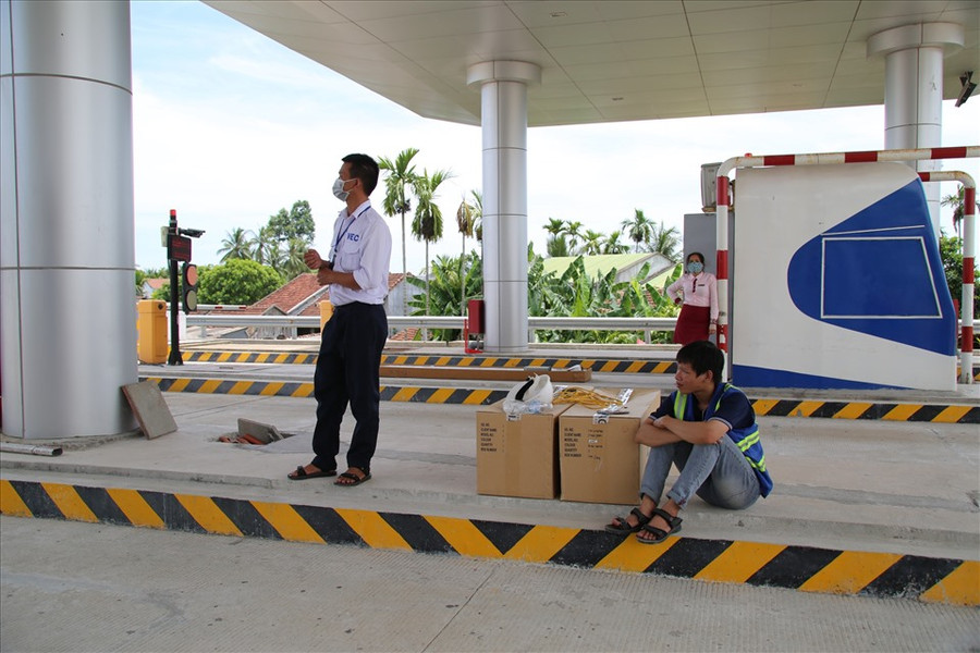Có thời điểm trạm thu phí khá vắng vẻ, nhân viên phải ngồi đợi xe chạy qua. Đại diện VETC (áo xanh) đi dọc đường dẫn tuyến cao tốc Đà Nẵng- Quảng Ngãi để hướng dẫn cho nhân viên tại các trạm thu phí cách thức vận hành hệ thống mới.