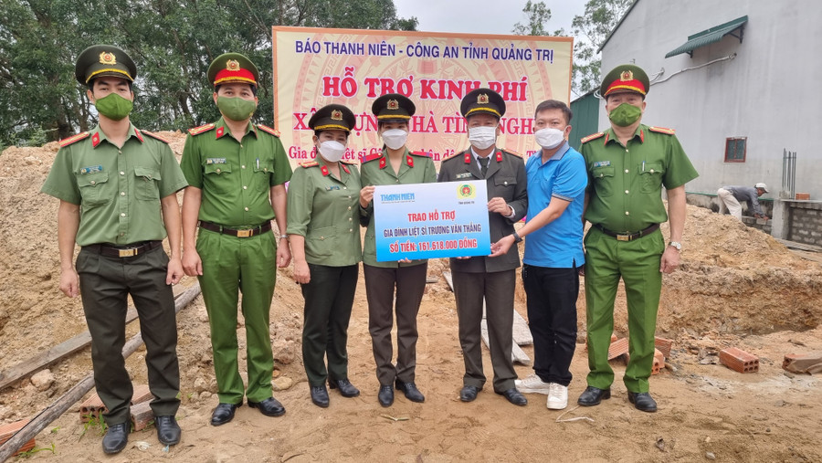 Đại tá Nguyễn Văn Thanh, Giám đốc Công an tỉnh Quảng Trị, và đại diện Báo Thanh Niên (thứ 3 và 2 từ phải sang) trao biển tượng trưng số tiền hỗ trợ xây nhà cho chị Lê Thị Minh Huê (vợ liệt sĩ Trương Văn Thắng). Ảnh: Thanh Lộc