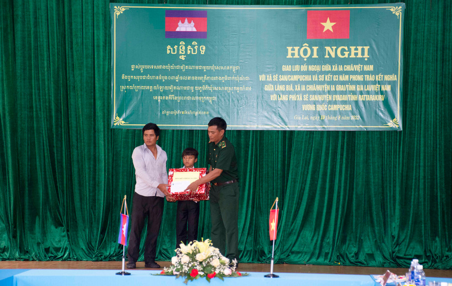 Đại diện Đồn Biên phòng tặng quà và trao học bổng cho em Rah Lan Mương, làng Phí từ Chương trình Nâng bước em đến trường. Ảnh: Đinh Yến