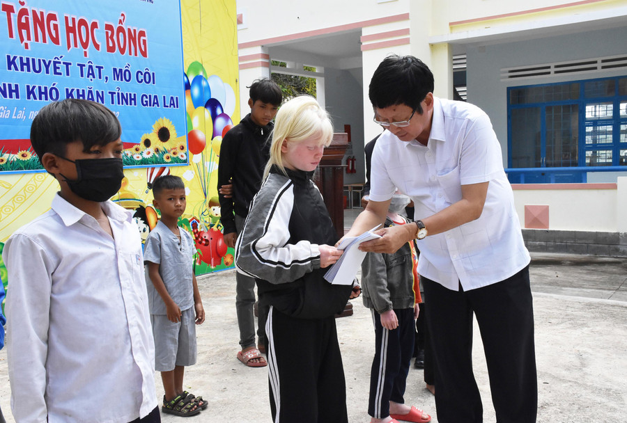 Ông Đỗ Mạnh Hùng tặng học bổng cho học sinh mồ côi huyện Kông Chro. Ảnh: Hà Phương