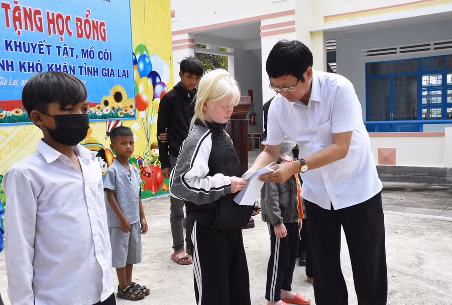 Ông Đỗ Mạnh Hùng tặng học bổng cho học sinh mồ côi huyện Kông Chro. Ảnh: Hà Phương