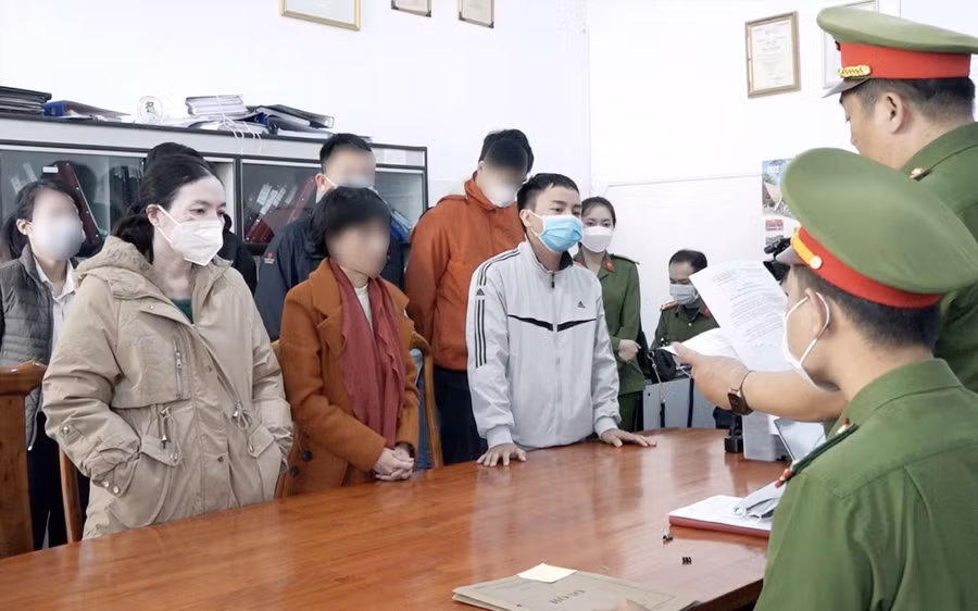 Công an đọc quyết định khởi tố, bắt tạm giam tại nơi làm việc của ông Đạt và bà Hoa. Ảnh: CACC