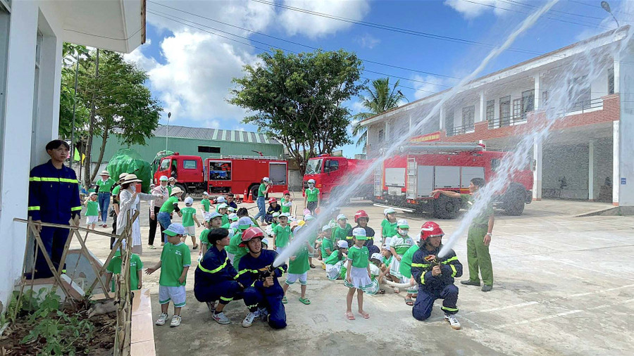 Học sinh Trường Mầm non Sắc Màu (phường Tây Sơn, thị xã An Khê) được hướng dẫn một số động tác đơn giản trong quy trình chữa cháy. Ảnh: Mộc Trà