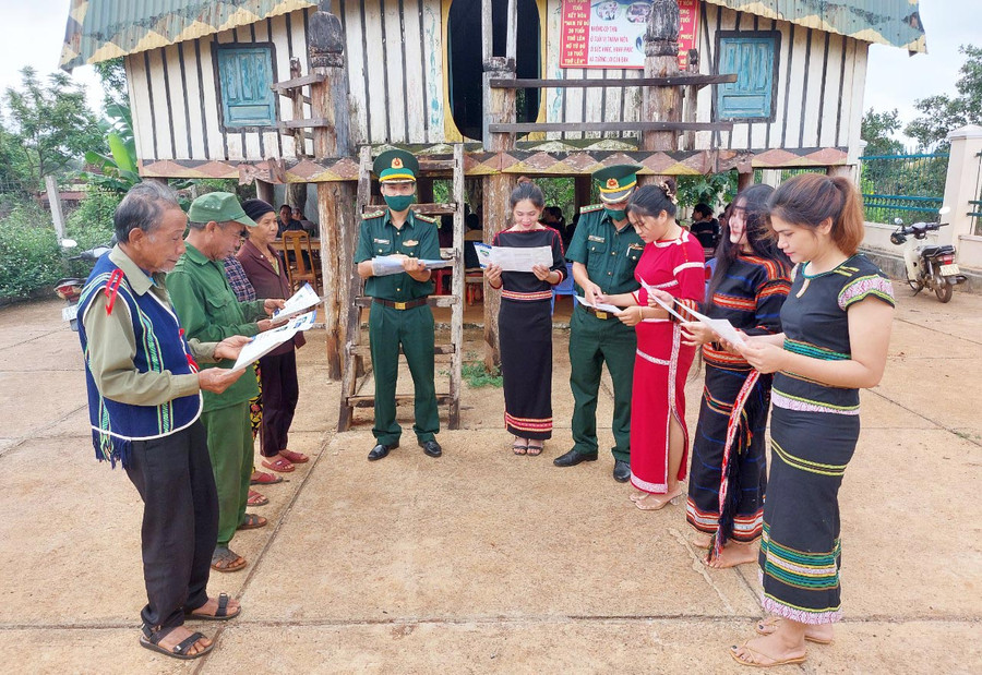 Già làng Rơ Châm Trôm (bìa trái; làng Chan, xã Ia Pnôn, huyện Đức Cơ) cùng Bộ đội Biên phòng tuyên truyền, vận động người dân. Ảnh: Vĩnh Hoàng