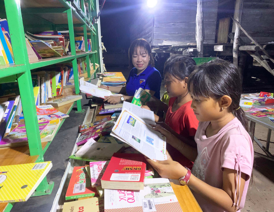 Các em thiếu nhi đọc sách tại xe thư viện lưu động. Ảnh: Vũ Chi Các em thiếu nhi đọc sách tại xe thư viện lưu động. Ảnh: Vũ Chi