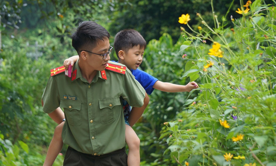 Cháu Vi Việt Dũng thích được cõng trên lưng. Mỗi lần đồng đội của anh Luân đến thăm đều cõng cháu đi quanh nhà