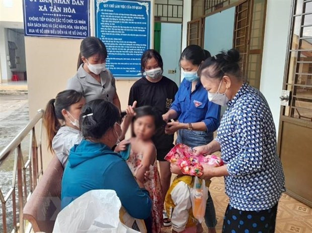 Các hội, đoàn thể của huyện và xã Tân Hòa sửa soạn cho bé L.Y.S. trước khi bé về quê cùng cha ruột. Ảnh nguồn TTXVN