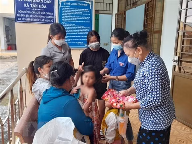 Các hội, đoàn thể của huyện và xã Tân Hòa sửa soạn cho bé L.Y.S. trước khi bé về quê cùng cha ruột. Ảnh nguồn TTXVN