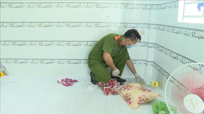 Lực lượng Công an khám nghiệm hiện trường vụ án. Ảnh: TTXVN