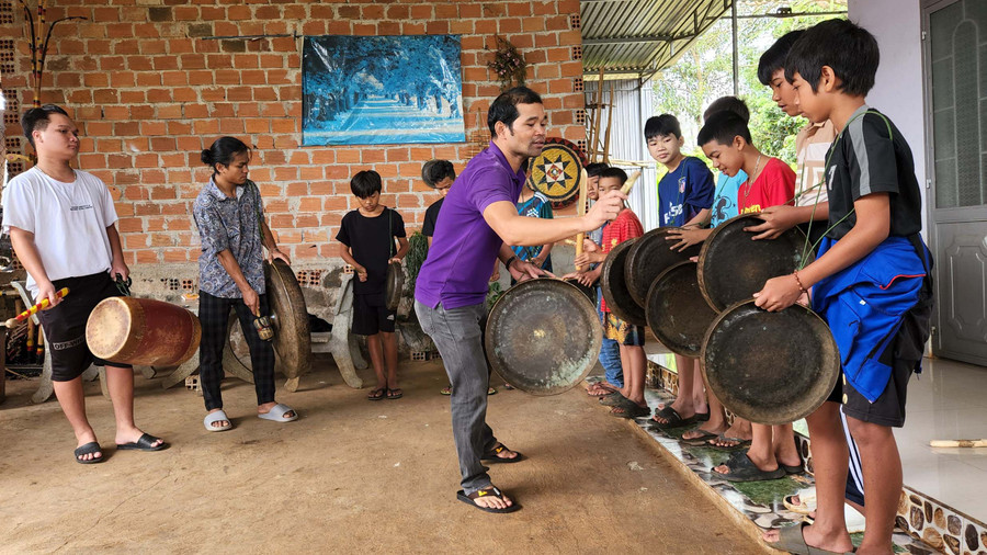 Anh Siu Thưm hướng dẫn các em nhỏ làng Pleiku Roh (phường Yên Đổ, TP. Pleiku) đánh cồng chiêng. Ảnh: Phan Lài Anh Siu Thưm hướng dẫn các em nhỏ làng Pleiku Roh (phường Yên Đổ, TP. Pleiku) đánh cồng chiêng. Ảnh: Phan Lài