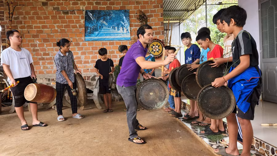 Anh Siu Thưm hướng dẫn các em nhỏ làng Pleiku Roh (phường Yên Đổ, TP. Pleiku) đánh cồng chiêng. Ảnh: Phan Lài