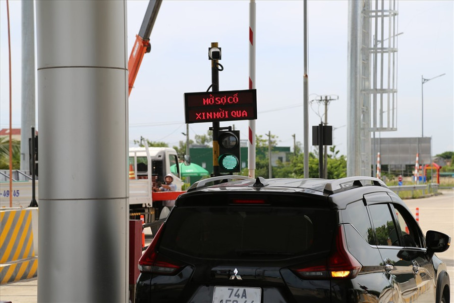 Nhiều xe được lưu thông khi nhân viên thu phí khắc phục xong sự cố không nhận diện được thẻ ETC. Nhân viên (áo xanh) hướng dẫn cho khách hàng cách thức nạp tiền vào tài khoản để đủ điều kiện lưu thông trên cao tốc.