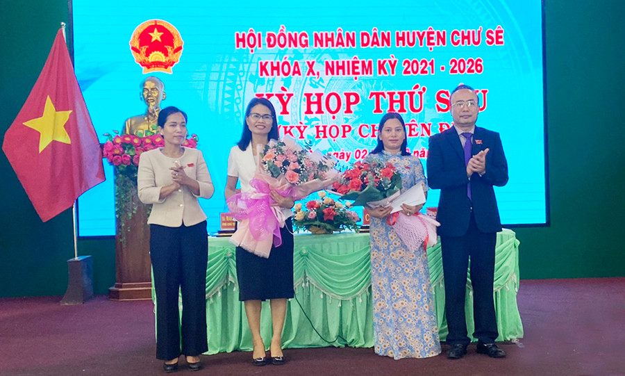 Ông Nguyễn Hồng Hà bên phải và bà Rmah H’Bé Nét bên trái tặng hoa chúc mừng bà Kpui H'Blê và bà Rah Lan H'Thanh tại kỳ họp. Ảnh: Hoàng Viên