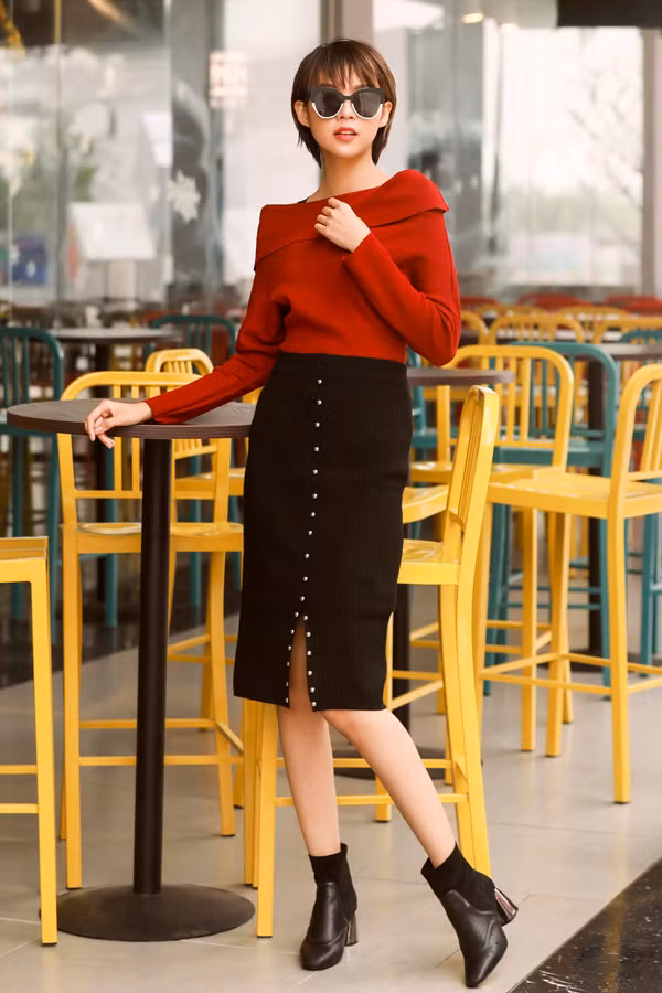 Người mẫu chọn cho mình chiếc áo trễ vai màu đỏ mix cùng chân váy xẻ kết hợp cùng mắt kính và bốt đen cổ ngắn. Bộ trang phục mang màu sắc lễ hội với phom dáng trẻ trung, hợp xu hướng chắc hẳn sẽ giúp các cô gái tự tin, nổi bật hơn khi dạo phố.