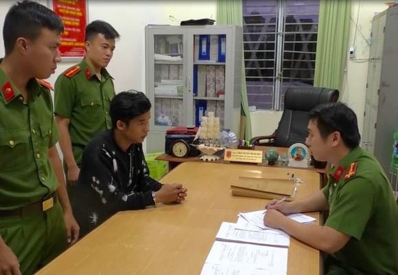 Đối tượng Thành (áo đen) làm việc tại trụ sở công an.