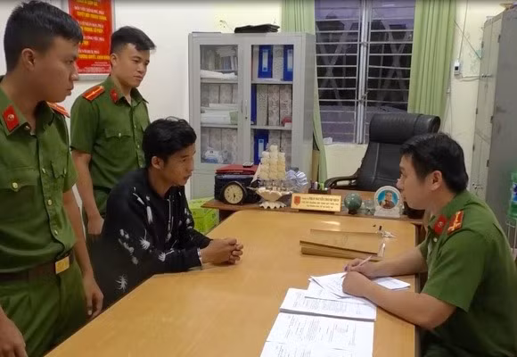 Đối tượng Thành (áo đen) làm việc tại trụ sở công an.