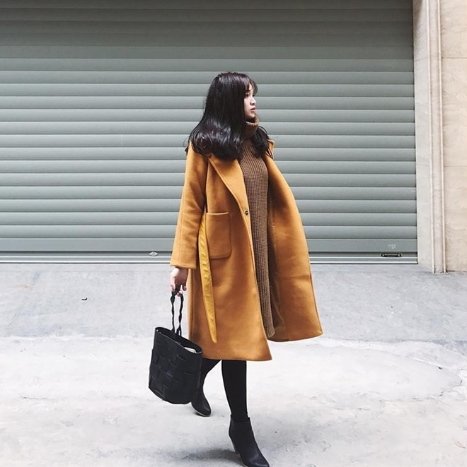 Hà Nội trở lạnh khiến Ngọc Mon có cơ hội chưng diện cùng lúc đầm len cổ lọ và áo khoác dáng dài. Cô nàng lựa chọn thiết kế có gam màu tươi tắn, phối ăn ý cùng leggings và boots cao gót tiệp màu đen.