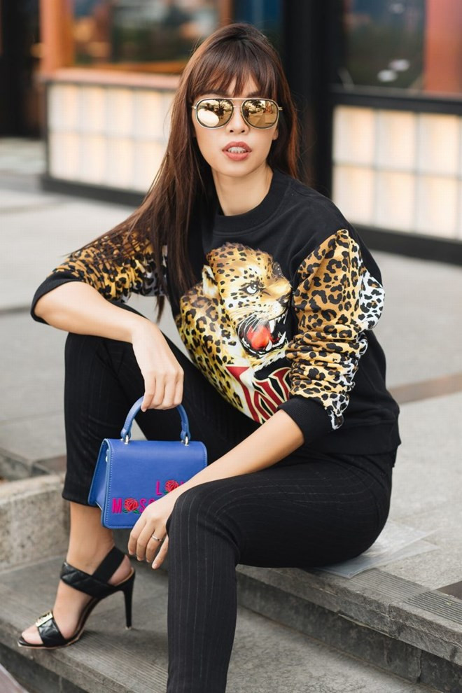  Áo sweater in họa tiết báo trước ngực và họa tiết da báo trên hai tay áo được cô phối cùng quần pinstriped và sandals cao gót mang phong cách quý cô thành thị.