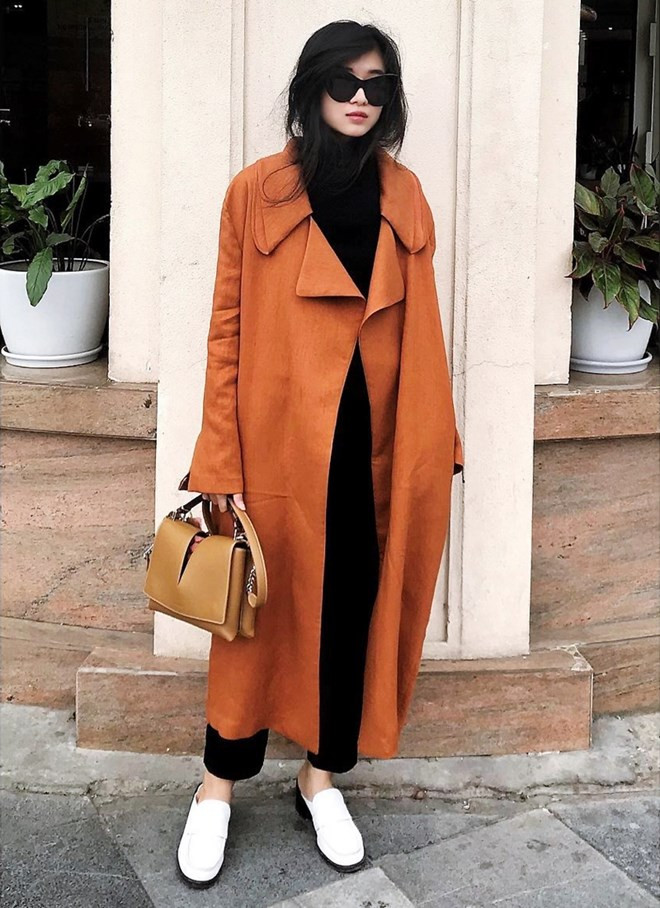 Ngô Thái Bảo Loan cũng ưu tiên những món đồ hơi hướng tối giản trong ngày lạnh. Để ''thắp sáng'' bộ đồ tuyền đen, nhà thiết kế trẻ kết hợp duster coat phủ sắc nâu vàng, mang giày xỏ trắng năng động.