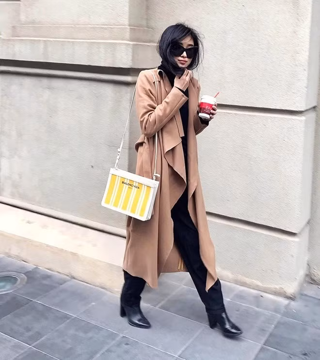 Bên cạnh duster coat, Ngô Thái Bảo Loan còn chưng diện cardigan dài qua đầu gối, mix cùng bộ đồ ''đen toàn tập'' và không quên tạo điểm nhấn bằng túi Balenciaga, có giá lên tới gần 20 triệu đồng.