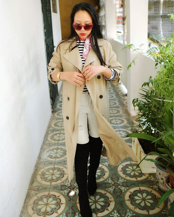 Đặng Trầm lan tỏa cảm hứng Parisian với set đồ mang đậm cảm hứng cổ điển. Không chỉ diện áo thun kẻ ngang, mang boots cao quá gối, chủ xị trang blog ''Dear Ladies'' còn ghi điểm ấn tượng khi phối bộ cánh với áo khoác trench, điểm trang bằng khăn quàng cổ theo tinh thần của quý cô người Pháp.