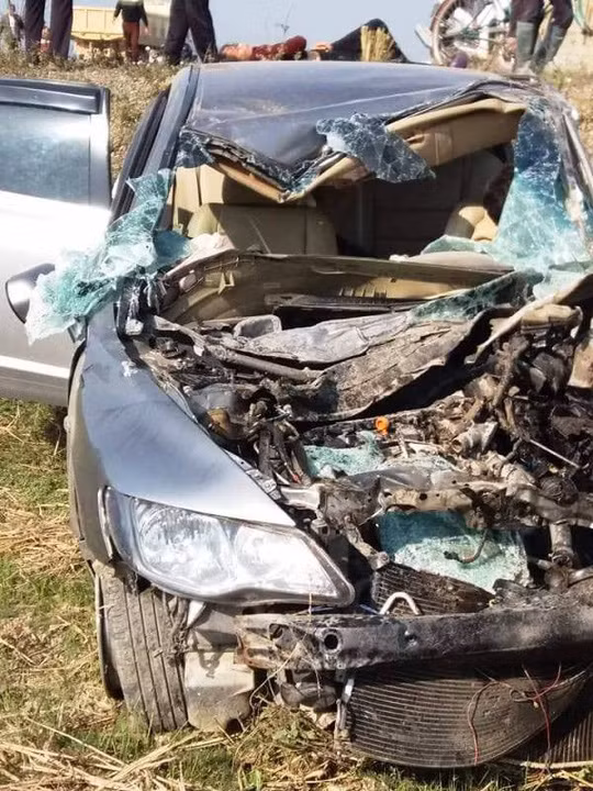 Vụ tai nạn khiến chiếc xe con nát bét phần đầu, xe tải lật ngửa bên vệ đường.