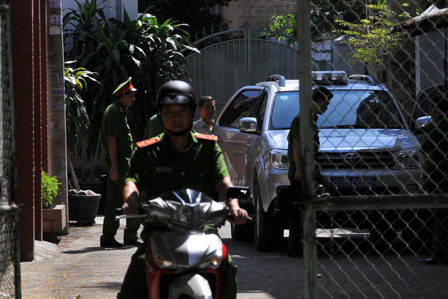 Sau khi khám xét, ông Minh bị áp giải lên xe công an