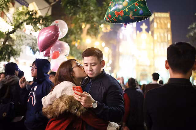 Cô gái trẻ trao tặng nụ hôn nồng nàn cho người yêu của mình trước cửa Nhà thờ Lớn