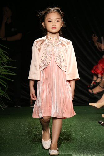 Bé Diễm Quỳnh đã thể hiện nét đáng yêu qua chiếc đầm hồng với chất liệu satin cổ điển, cùng những hình thêu đặc trưng trên áo.