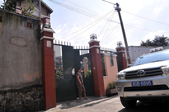 Xe của công an đậu trước nhà riêng của ông Minh để thực hiện khám xét