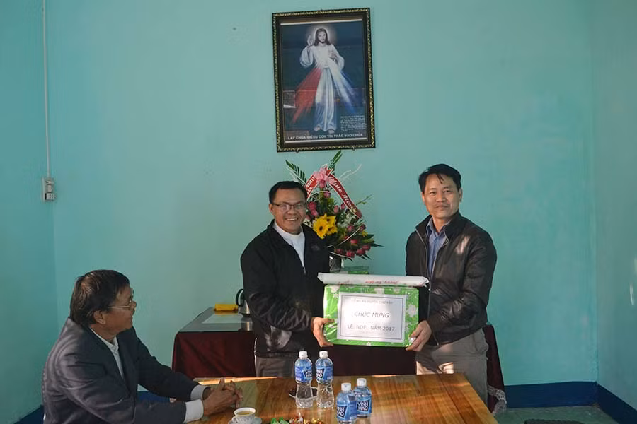  Trung tá Nguyễn Duy Anh-Phó trưởng Công an huyện Chư Pah(bên phải) tặng quà cho Linh mục Nguyễn Minh Đức-Chánh xứ Ninh Đức, xã Nghĩa Hòa, huyện Chư Pah. Ảnh: Hoàng Cư