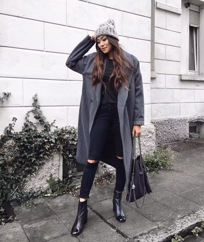 Yêu thích phong cách tối giản, Thảo Nhi lựa chọn áo khoác màu xám tro làm trang phục phủ ngoài bộ cánh tuyền đen, vừa giữ ấm, vừa làm bật vẻ cá tính. Bộ cánh mang đậm dấu ấn minimalist, kết hợp boots da cao gót còn là gợi ý hoàn hảo để các cô gái tạo được dáng người mảnh mai, ''ăn gian'' chiều cao đáng kể.