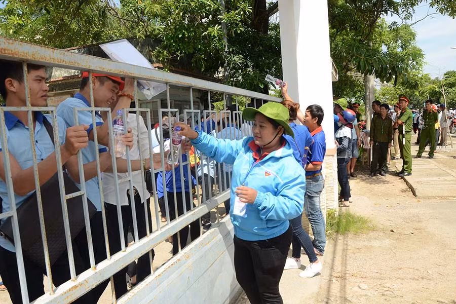  2-Thanh niên tình nguyện Huyện Đoàn Phú THiện tiếp nước cho thí sinh. Ảnh: Đức Phương