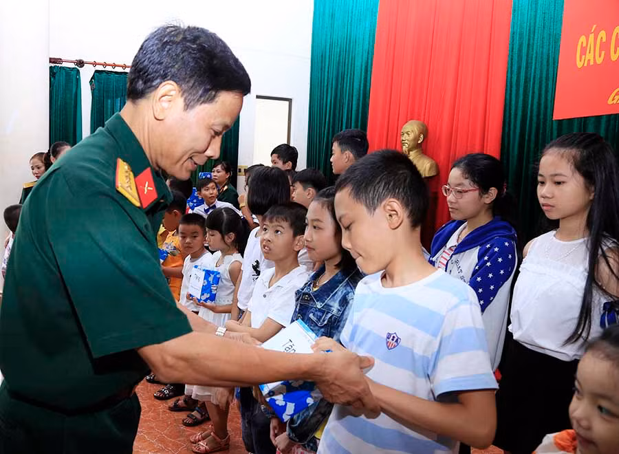  Đại tá Nguyễn Văn Thế, Phó Chủ nhiệm Chính trị Quân đoàn 3 (người đứng giữa) tặng quà cho các cháu đạt học sinh giỏi. Ảnh: Vũ Duy Hiển