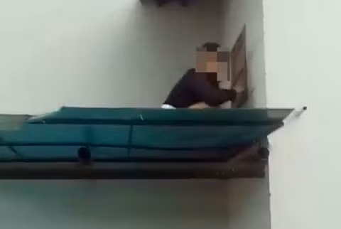  Hình ảnh bà M. leo trèo bên ngoài cửa sổ thông gió phòng nghỉ