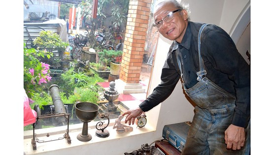 Ông Quý bên những cổ vật, kỷ vật chiến tranh đã sưu tầm được.