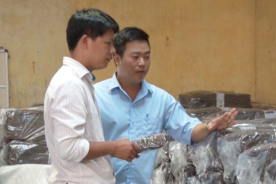 Anh Trần Đình Hiệu (bên phải) trao đổi với đồng nghiệp về chất lượng mủ cao su. Ảnh: H.Đ.T