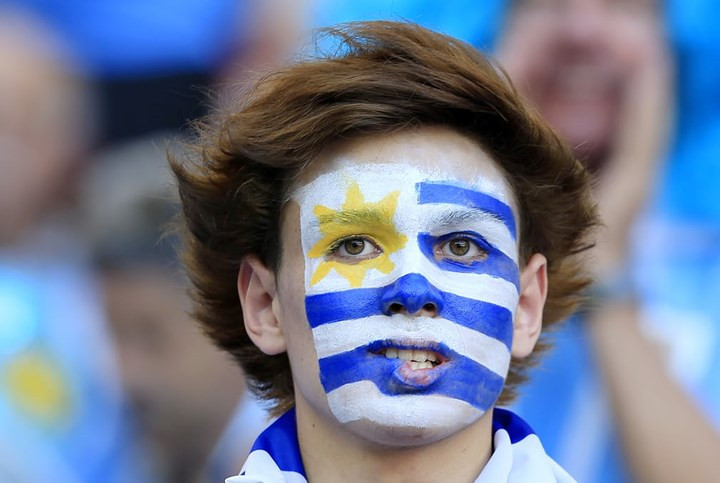 Cổ động viên Uruguay tô hình lá cờ trên khuôn mặt.