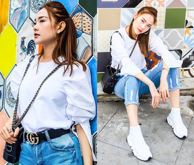 Minh Hằng dùng thắt lưng Gucci làm điểm nhấn eo duyên dáng cho cặp đôi áo blouse trắng tay phồng và quần jeans rách. Giọng ca ''Em xin anh'' hoàn thiện phong cách bằng đôi giày thể thao trắng, tăng vẻ sành điệu nhờ túi Gabrielle của Chanel.