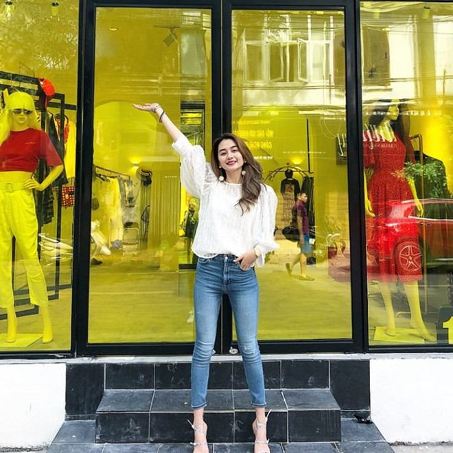 Thiều Bảo Trang hết mực thanh lịch với áo blouse trắng tay phồng, phối cùng quần jeans và sandals cao gót. Combo 3 món đồ lý tưởng đã khai thác triệt để lợi thế hình thể, khoe khéo vóc dáng mảnh mai của nữ ca sĩ.