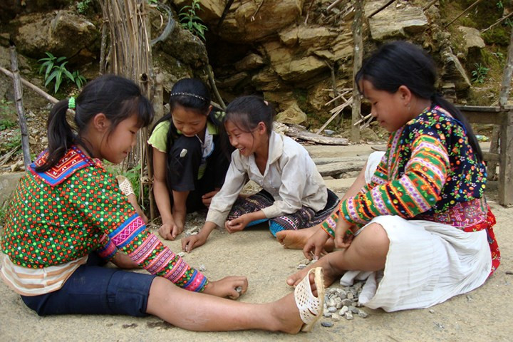  Còn trẻ em dân tộc Mông ở vùng cao huyện Phong Thổ lại tự chơi bên vệ đường, với bụi đất, đá sỏi