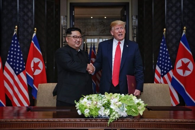 Tổng thống Mỹ Donald Trump (phải) và nhà lãnh đạo Triều Tiên Kim Jong-un sau lễ ký văn kiện. (Nguồn: AFP) Tổng thống Mỹ Donald Trump (phải) và nhà lãnh đạo Triều Tiên Kim Jong-un sau lễ ký văn kiện. (Nguồn: AFP)